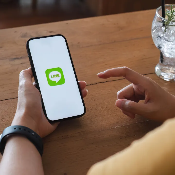 スマートフォンのLINE画面を操作している様子。パーソナルトレーニング中の食事指導を受けているシーンをイメージ