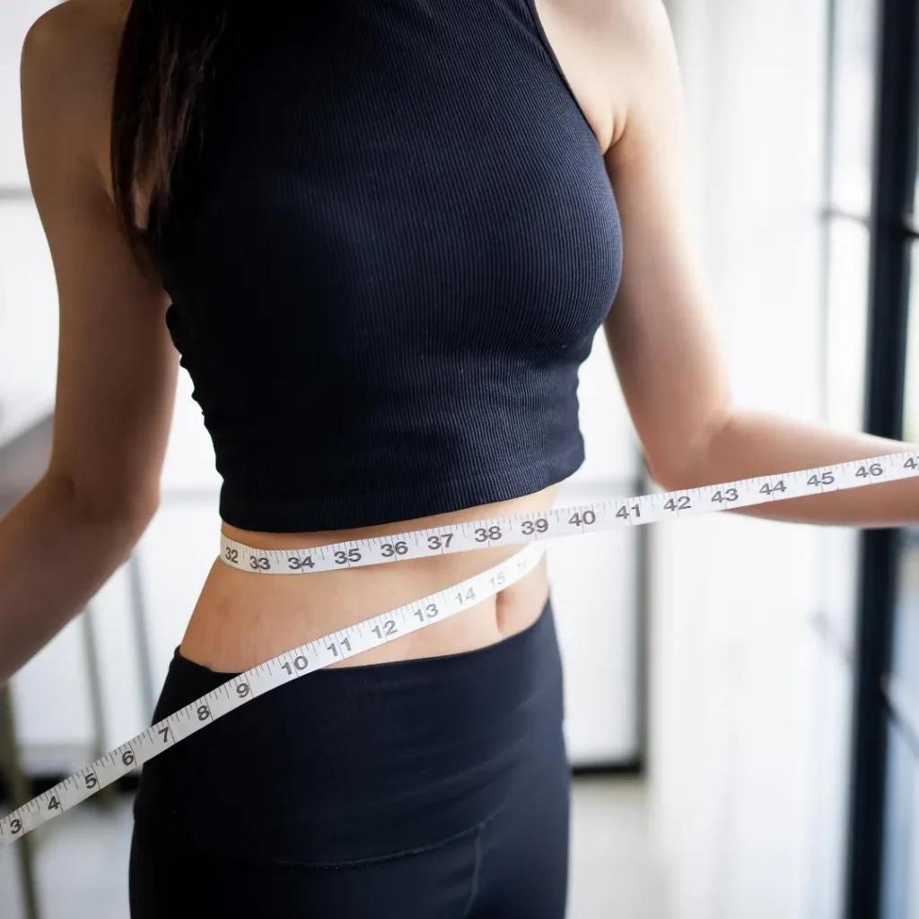 ウエストをメジャーで測る女性のダイエット中の様子。札幌のパーソナルジムで提供している目的別ダイエットサポートのイメージ。