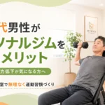 50代男性が完全個室パーソナルジムでダンベルプレスのフォーム指導を受けながら運動を始める様子