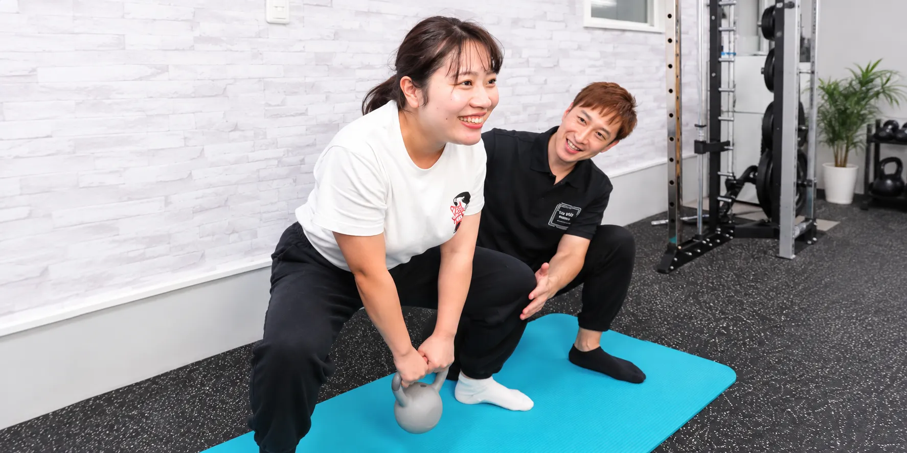 札幌市西区・発寒のキースタイルフィットネスで女性利用者を藤川啓介トレーナーがマンツーマン指導している様子